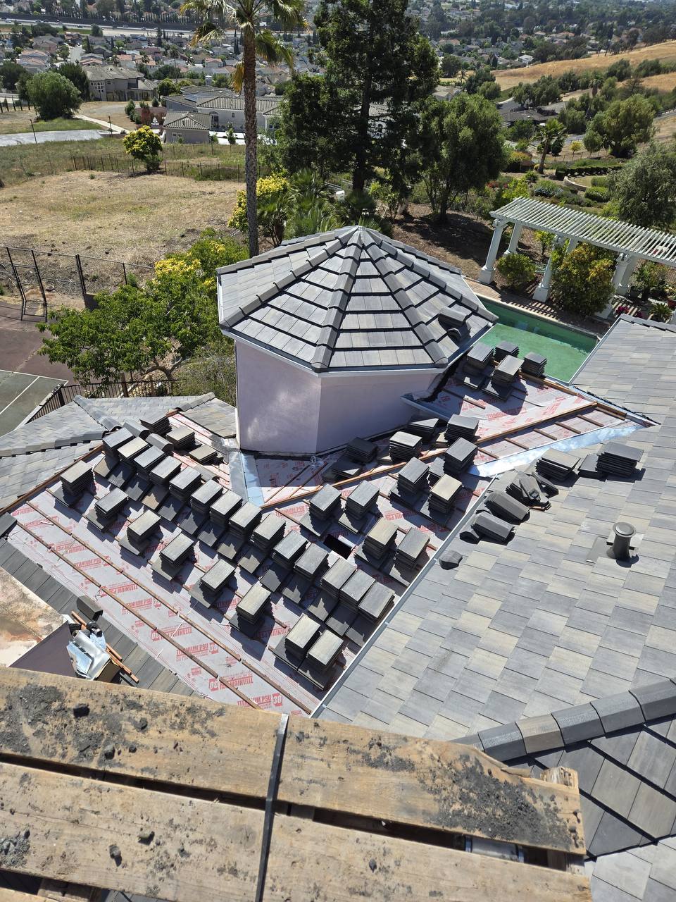 Concrete tile staged for installation around an octagonal turret roof feature